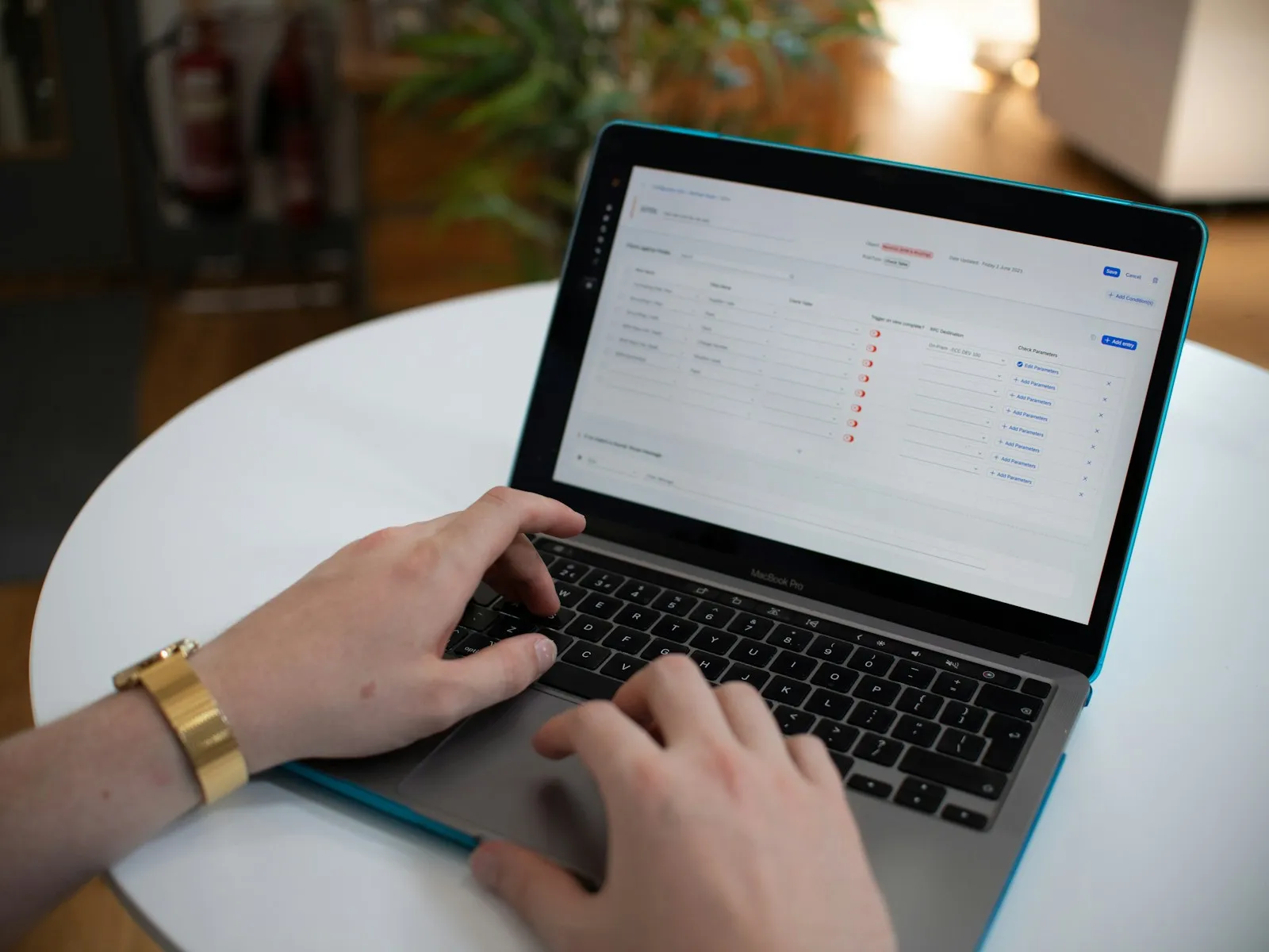 Hands typing on a laptop with a spreadsheet on the screen