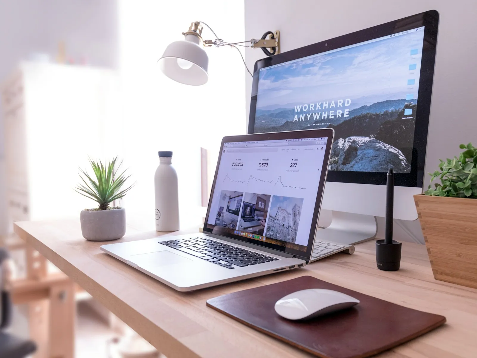 A laptop and a desktop computer on a desk, with a website on the screen